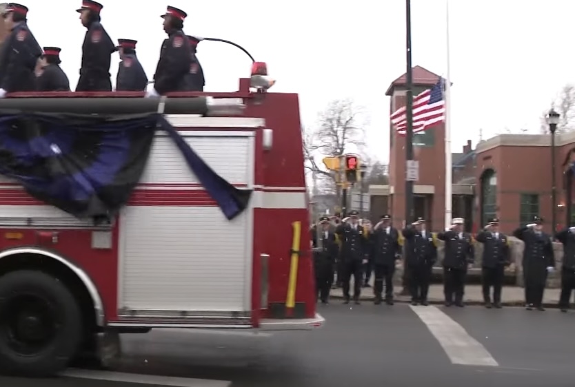 Firefighters in uniform saluting